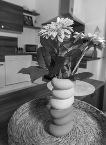 a vase with flowers in it on a table at (W)einHaus am See in Rust