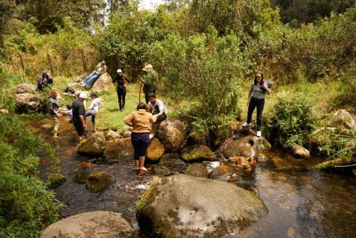 a group of people standing on rocks in a stream at Glamping - Domo el Frailejón con Jacuzzi in Villapinzón