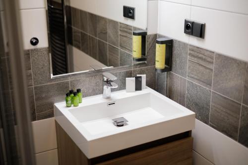 a bathroom with a white sink and a mirror at River Apartments in Mladá Boleslav