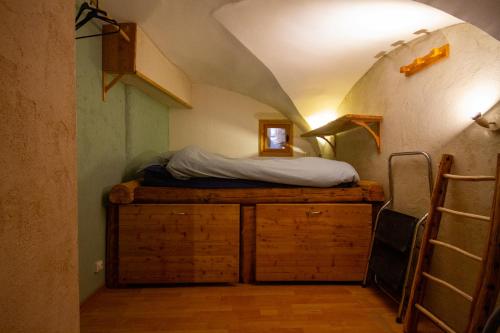 - une chambre avec un lit au-dessus d'une armoire en bois dans l'établissement Charmant Appartement de 39m2 à Guillestre, à Guillestre