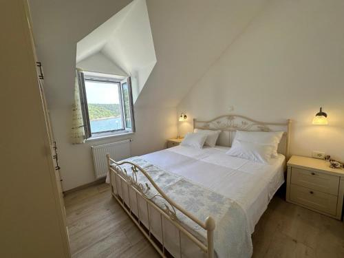 a bedroom with a large bed and a window at House Ana in Pučišća
