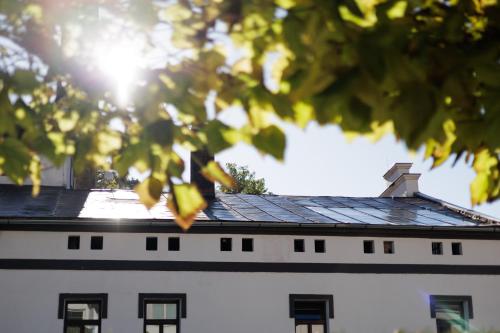 a building with a roof with the sun in the background at River Apartments in Mladá Boleslav