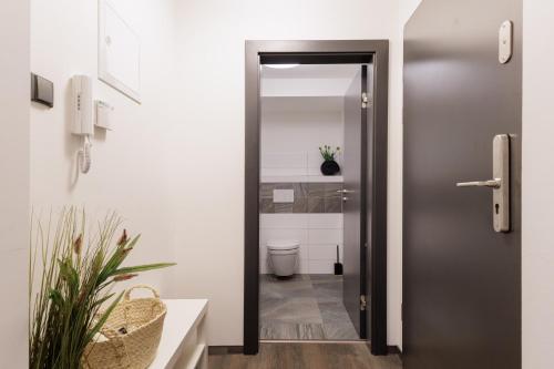 a bathroom with a door leading to a toilet at River Apartments in Mladá Boleslav