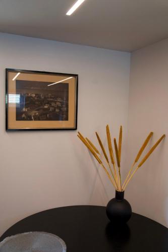 a black vase on a table with a picture on the wall at ÅNDALSNES UNDERGROUND flat in Åndalsnes