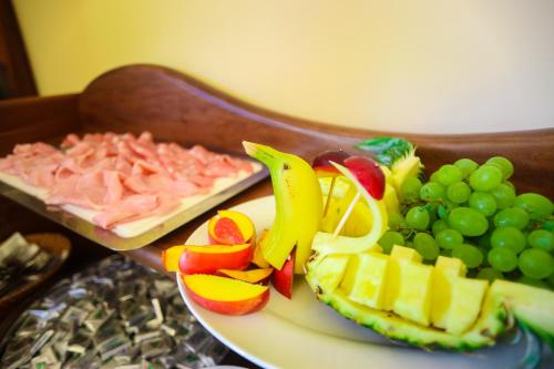 a plate of food with meat fruit and grapes at Villaggio Hotel Lido San Giuseppe in Briatico
