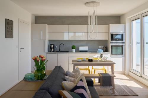 a kitchen and living room with a couch and a table at Apartament z tarasem Panorama in Kołobrzeg