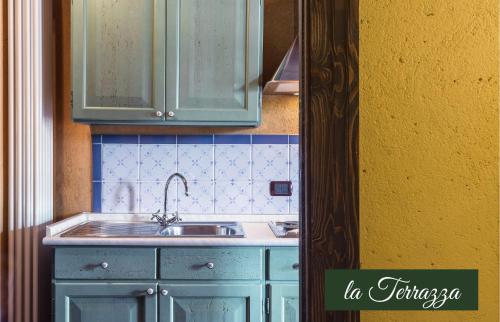 a kitchen with green cabinets and a sink at Il Borghetto Vacanze nei Mulini in Valeggio sul Mincio