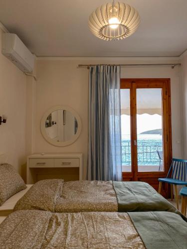 a bedroom with a bed and a large window at Nostos in Tolo