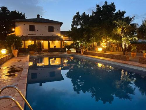 uma piscina em frente a uma casa à noite em Villa VEDA em Randazzo
