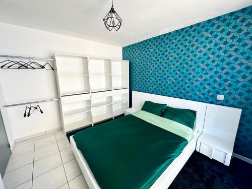 - une chambre avec un lit vert et des étagères blanches dans l'établissement Appartement à 50m de la plage, à Saint-Hilaire-de-Riez