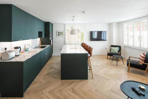 une cuisine avec des placards verts et un salon dans l'établissement 2Bed 2Bath Stunning Shoreditch Apartment, à Londres