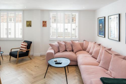 - un salon avec un grand canapé et une table dans l'établissement 2Bed 2Bath Stunning Shoreditch Apartment, à Londres