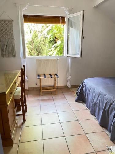 une chambre avec un lit, un bureau et une fenêtre dans l'établissement «  La PETITE MAISON » ....Des grands espaces..., à Saint-Maur-des-Fossés