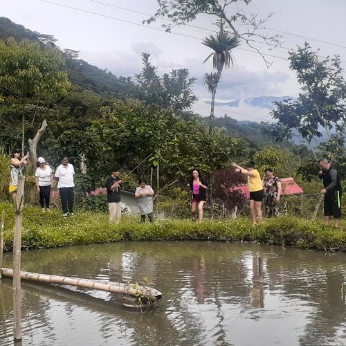 a group of people standing around a body of water at Glamping eco descanso la vega Nocaima in Nocaima