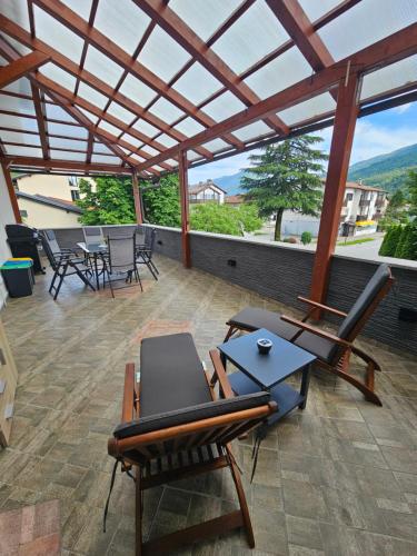 a patio with chairs and a table and a roof at SMARAGD Damir Antunovic-sobodajalec in Kobarid