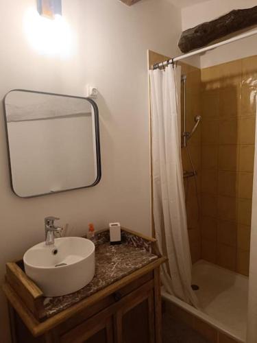 a bathroom with a sink and a shower with a mirror at L'Alorenlis, duplex vue lac de Sainte Croix in Bauduen
