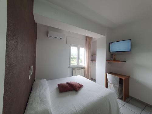 1 dormitorio blanco con 1 cama con 2 almohadas en Hotel Ristorante Supersonik, en Acri