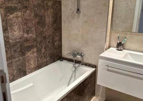 een badkamer met een bad en een wastafel bij appart très luxueux 6 personnes in El Ahmar