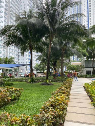 un parque con palmeras y una acera en #35 Grass residences tower2, en Manila