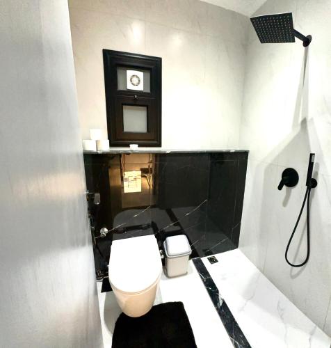 a bathroom with a toilet and a clock on the wall at Luxury Nile view , Cornish Nile in Cairo