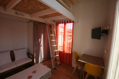 une petite pièce avec une échelle et une pièce avec une table dans l'établissement PIGEONNIER 10m2 au sol plus mezza plus sdb, à Saint-Raphaël