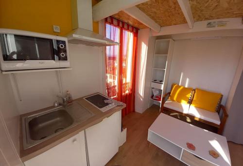 une petite cuisine avec un évier et un micro-ondes dans l'établissement PIGEONNIER 10m2 au sol plus mezza plus sdb, à Saint-Raphaël