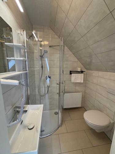een badkamer met een douche, een toilet en een wastafel bij Gap Hotel event & more in Langwedel
