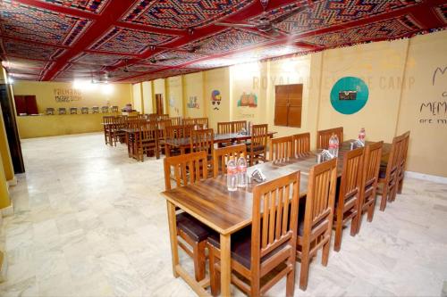 uma sala de jantar com mesas e cadeiras de madeira em Royal Adventure Camp & Resort em Jaisalmer
