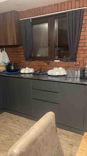 a kitchen with a black counter top with a chair at My Family hotel in Tbilisi City