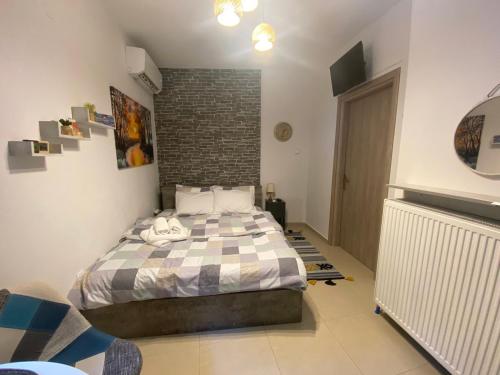 ein Schlafzimmer mit einem Bett und einer Ziegelwand in der Unterkunft Central & Riverfront Room in Edessa