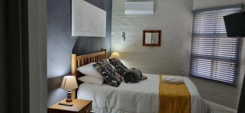 a dog laying on a bed in a bedroom at Hermanus 13 on 2nd Guest Rooms in Hermanus
