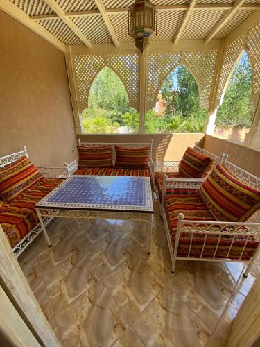 a room with chairs and a table in a room with windows at Villa Ourika ,Atlas in Ourika