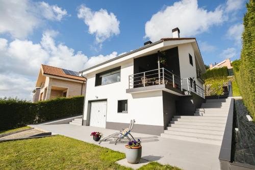 a white house with stairs and a balcony at Casa Buena Vista in Candás