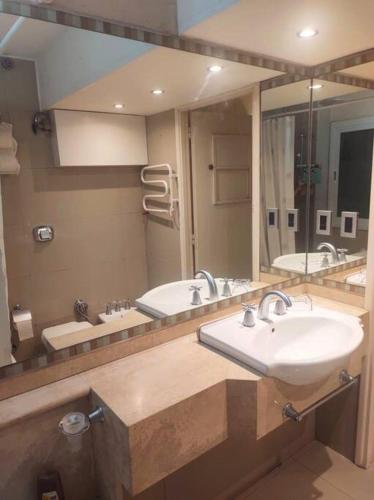 a bathroom with two sinks and a large mirror at Espacioso departamento céntrico. in San Juan