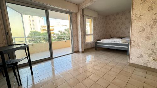 une chambre vide avec un lit et un balcon dans l'établissement Résidence La Miougrano Fréjus plage, à Fréjus