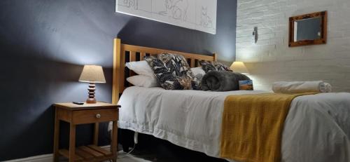 ヘルマナスにあるHermanus 13 on 2nd Guest Roomsのベッドとランプ付きのテーブルがある寝室
