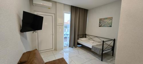 a room with a bed and a flat screen tv at TOPAZ four in Siviri
