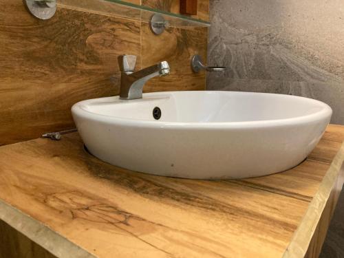 a white sink on a wooden counter in a bathroom at River Edge Yala in Tissamaharama