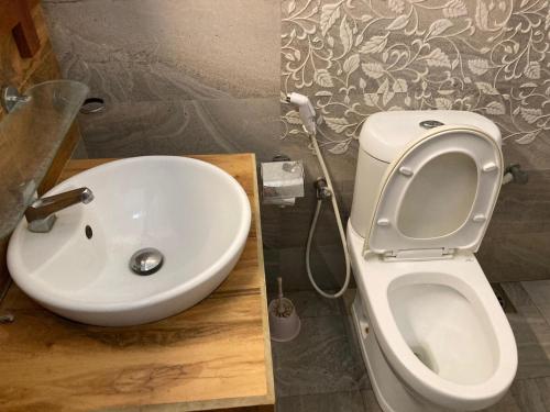 a bathroom with a white toilet and a sink at River Edge Yala in Tissamaharama