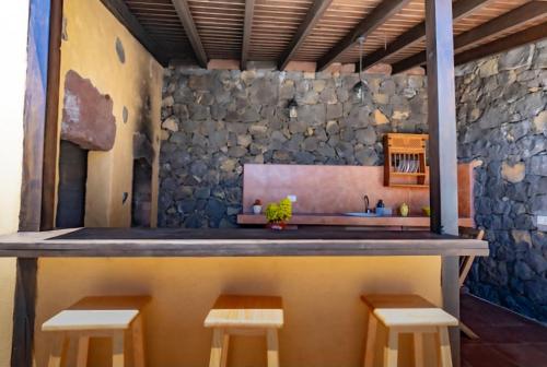 een keuken met een aanrecht met krukken en een wastafel bij Casa Esteban Y Facunda in Valverde