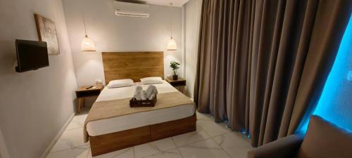 a small room with a bed and a television at TOPAZ three in Siviri