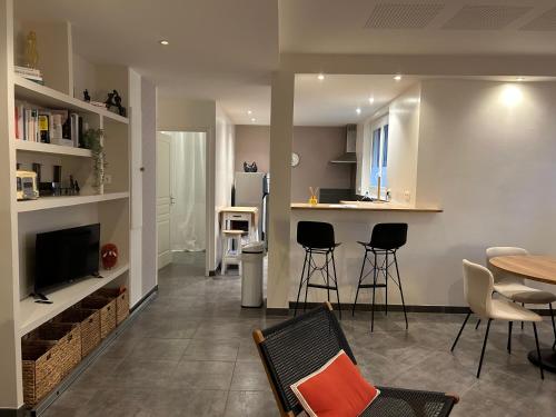 a living room with a table and chairs and a kitchen at L appart de Cathy in Cahors