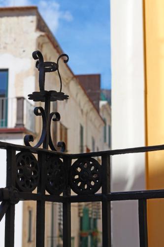a black metal fence with buildings in the background at Aqua Mirabilis Relais de Charme in Minori