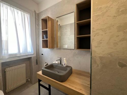 uma casa de banho com um lavatório e um espelho em NUOVO Bilocale Design Piazza Aurora - Adria Holiday Immobiliare Jesolo - Family Apartments em Lido di Jesolo