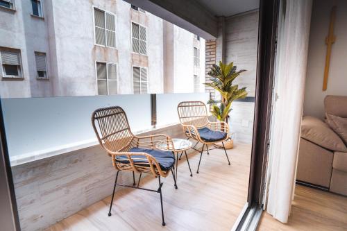 a balcony with three chairs and a table and a couch at Apartamento Boutique Beluga in Garrucha