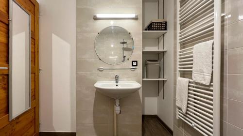 een badkamer met een wastafel en een spiegel bij L'Intermède & En toute amitié - Les Gites de l'Argile in Faucon-de-Barcelonnette