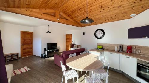 a kitchen and living room with a table and chairs at L'Intermède & En toute amitié - Les Gites de l'Argile in Faucon-de-Barcelonnette