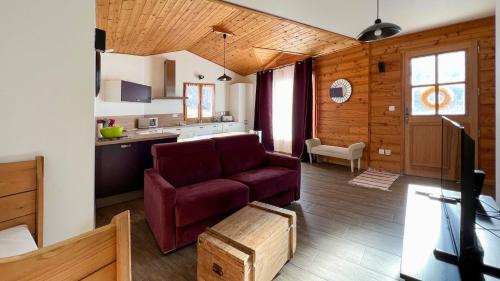 a living room with a couch and a kitchen at L'Intermède & En toute amitié - Les Gites de l'Argile in Faucon-de-Barcelonnette