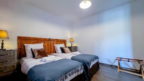 a bedroom with two beds with blue and white sheets at L'Intermède & En toute amitié - Les Gites de l'Argile in Faucon-de-Barcelonnette