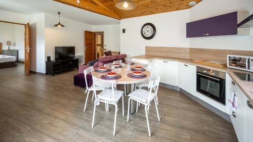 a kitchen and living room with a table and chairs at L'Intermède & En toute amitié - Les Gites de l'Argile in Faucon-de-Barcelonnette